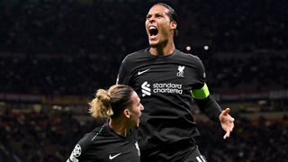 Virgil van Dijk celebrates his goal in the Champions League in his all black Liverpool away kit.